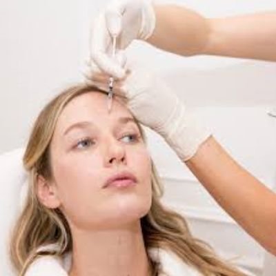 woman being injected to the forehead with PRP